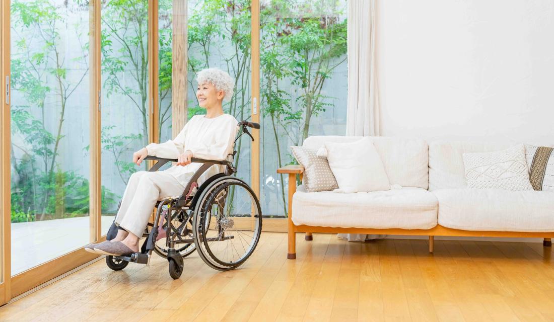 Frau im Rollstuhl schaut in den Garten